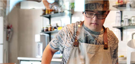 A young man with Down syndrome works in a cafe